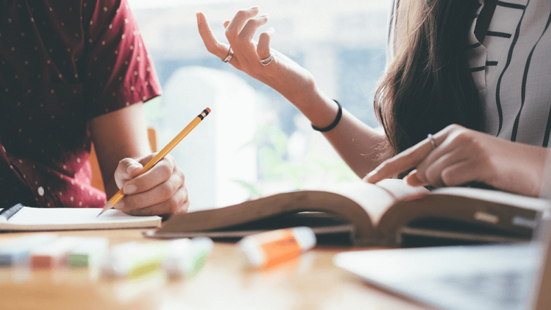 Two people sit next to each other and talk, showing how to improve emotional intelligence through strong communication skills 