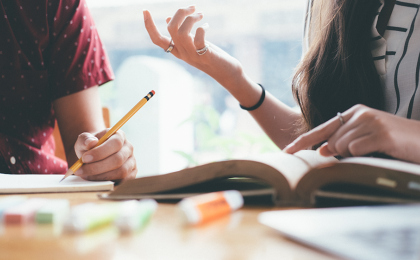 Two people sit next to each other and talk, showing how to improve emotional intelligence through strong communication skills 